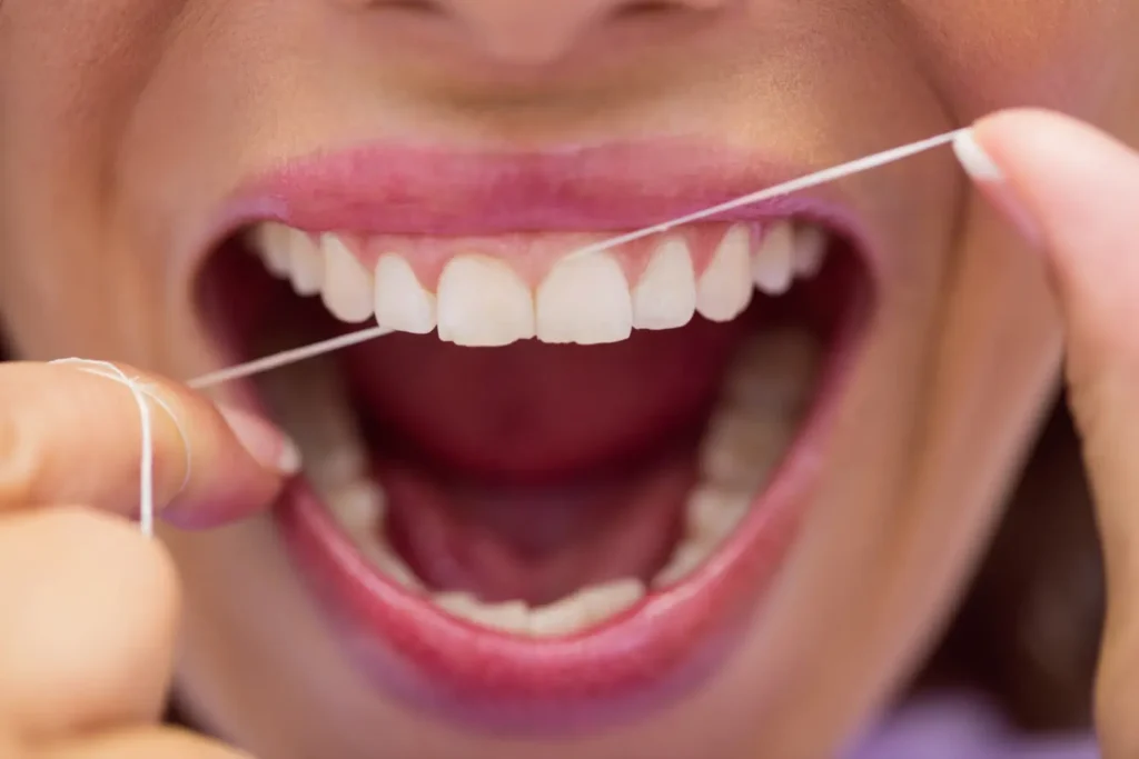 Persona pasándose el hilo dental