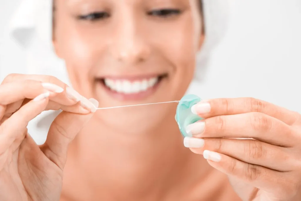 Persona sacando hilo dental de la caja