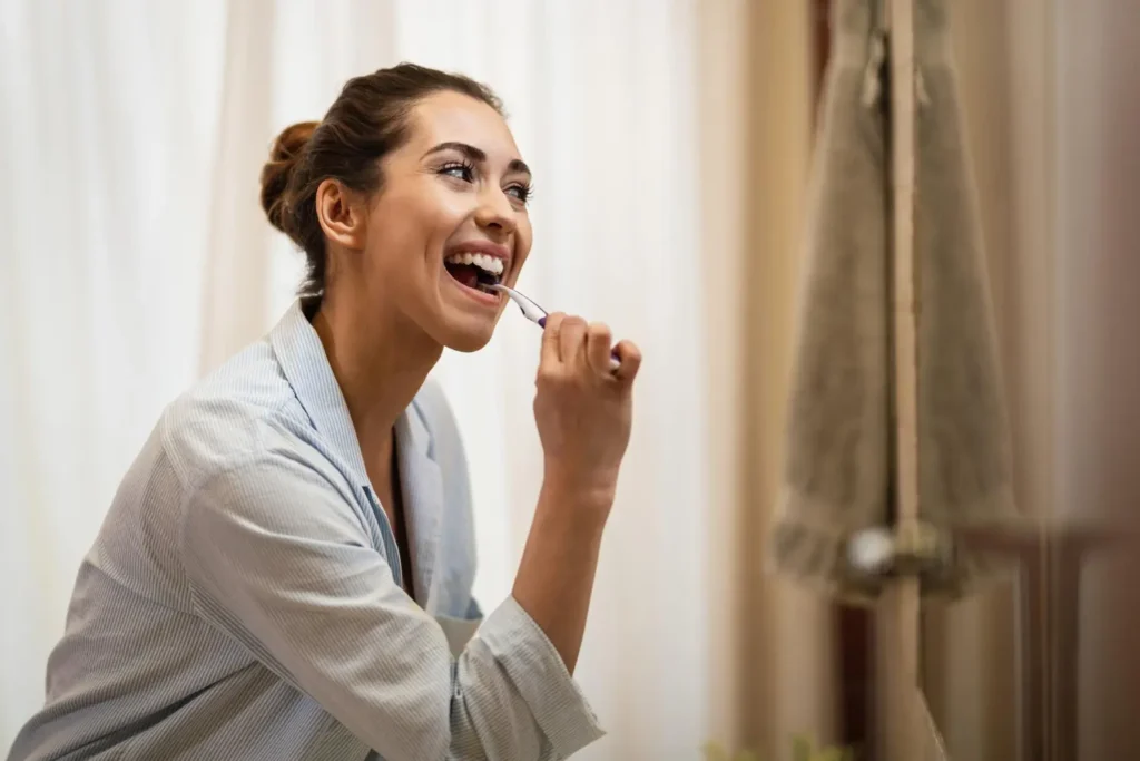 Chica cepillándose los dientes para tener una buena higiene bucal