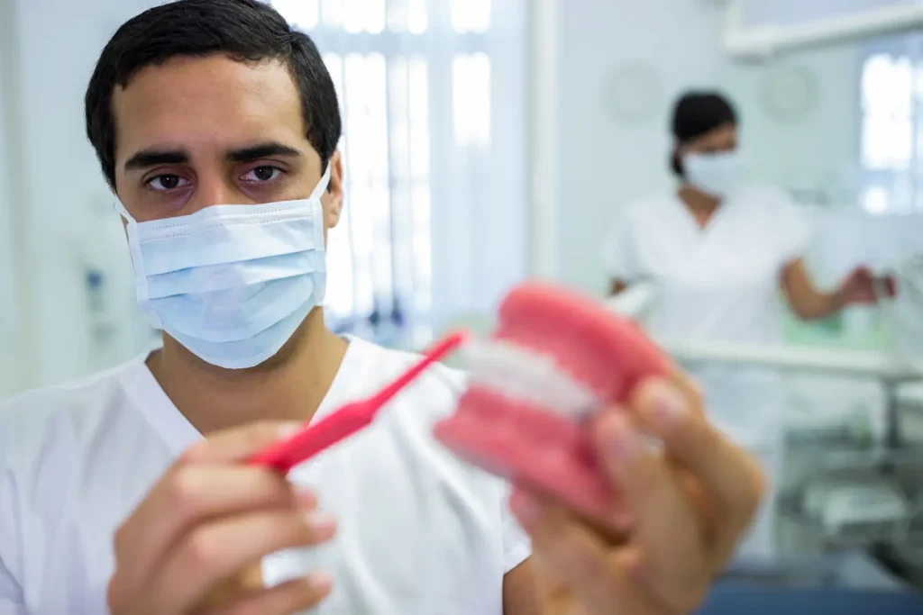 Odontólogo mostrando como cuidar dientes para no tener enfermedades bucodentales
