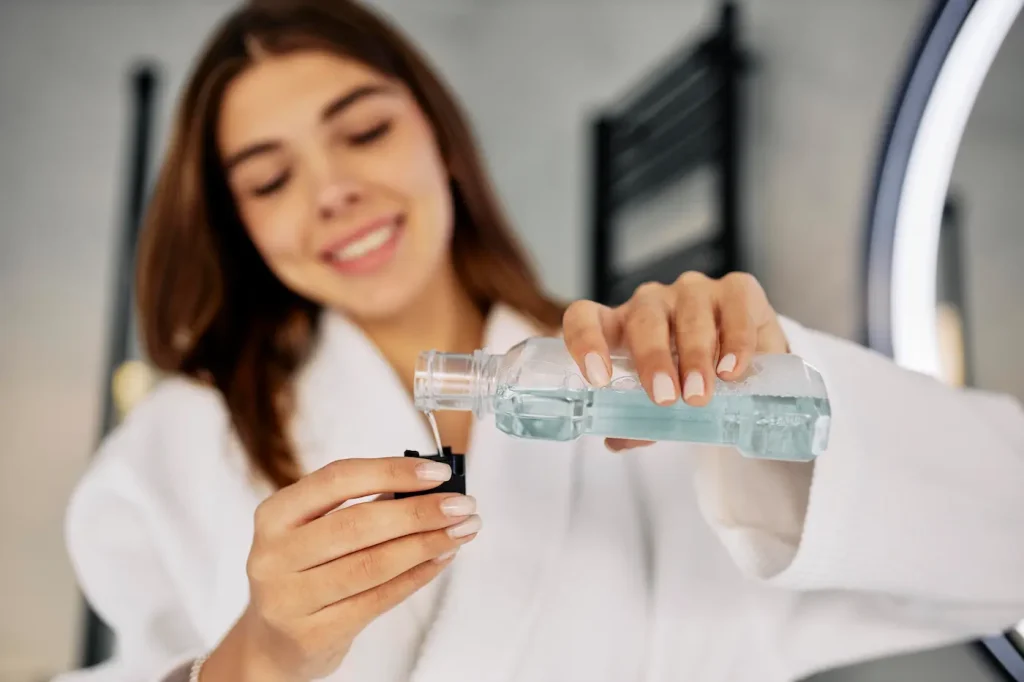 mujer enjuagándose los dientes